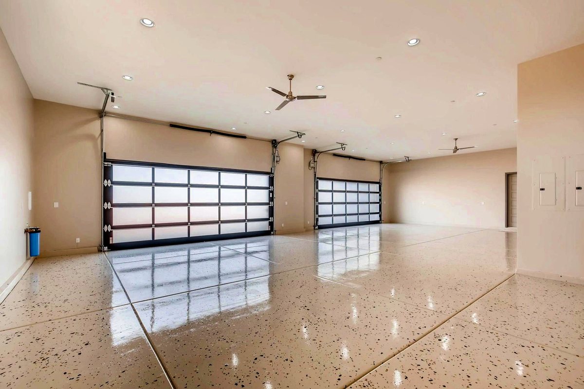 Interior of an oversized RV garage with full-glass doors and polished floor